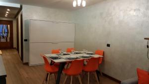 een eetkamer met een tafel en oranje stoelen bij Orange Fox Cervinia apartment Vda Vacanze in Vetta CIR 0185 in Breuil-Cervinia