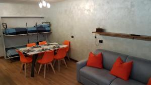een woonkamer met een bank en een tafel en stoelen bij Orange Fox Cervinia apartment Vda Vacanze in Vetta CIR 0185 in Breuil-Cervinia