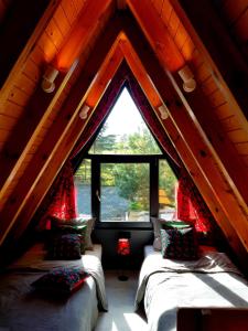 two beds in a room with a large window at U Hanki in Żywiec