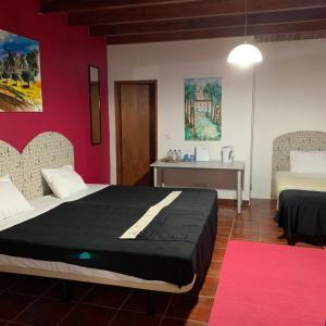 a bedroom with two beds and a pink wall at Monte do Paco in Montemor-o-Novo