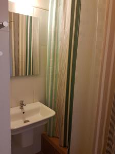 a bathroom with a sink and a shower curtain at HOTEL IVATO , Airport in Antananarivo +33 photos
