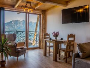 a living room with a table and a view of a mountain at Dom Tatrzański Ewa Deluxe in Kościelisko