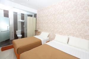 Postel nebo postele na pokoji v ubytování 1 Hotel Taman Connaught