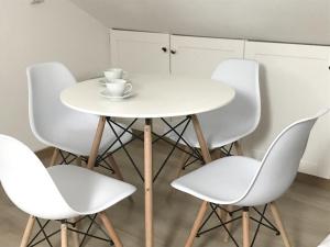 a white table with four chairs and a cup on it at Oak Tree Studio in Marlow