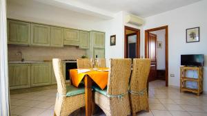 uma cozinha com uma mesa com uma toalha de mesa amarela em Carlo Felice em Santa Teresa Gallura