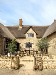 Artist Residence Oxfordshire في أوكسفورد: مبنى امامه طاولات وسياج