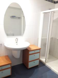 a white bathroom with a sink and a mirror at Precioso Duplex Cal Richi in Tremp