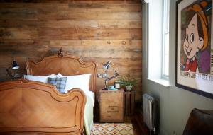 a bedroom with a wooden bed and a wooden wall at Artist Residence Brighton in Brighton & Hove
