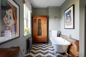 a bathroom with a white tub and a checkered floor at Artist Residence Brighton in Brighton & Hove