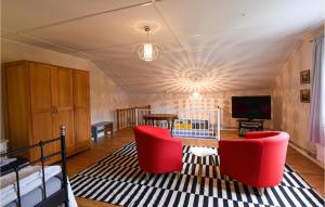 ein Wohnzimmer mit einem Tisch und roten Stühlen in der Unterkunft Awesome apartment in Grythyttan with 1 Bedrooms, Sauna and WiFi in Grythyttan