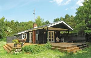 Ce petit cottage noir dispose d'une terrasse en bois. dans l'établissement Cozy Home In Humble With Kitchen, à Humble