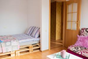 Habitación pequeña con cama y silla en Centro apartamentai en Naujoji Akmenė