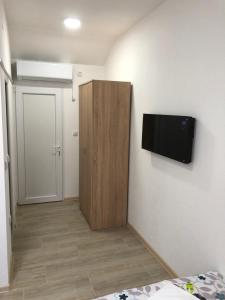 a room with a tv on the wall and a door at Prenoćište Binta in Vranje