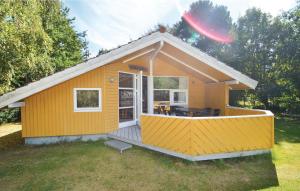 una pequeña casa amarilla con un frisbee en el aire en 2 Bedroom Amazing Home In Nakskov, en Kappel