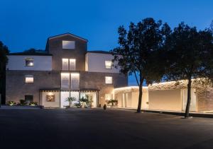 un gran edificio de ladrillo con un árbol delante de él en Finis Africae Hotel, en Senigallia