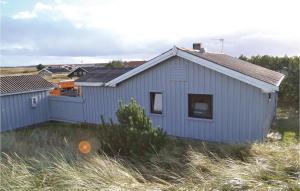 a white house with a fence in a field at Holiday Home Arvidvej Denmk Xii in Bjerregård