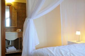 a bedroom with a bed and a sink and a mirror at Aegea Blue Cycladic Resort in Zorgos 