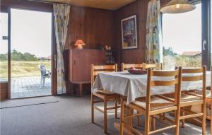a dining room with a table and chairs and a sliding glass door at Holiday Home Arvidvej Denmk Xii in Bjerregård +6 photos