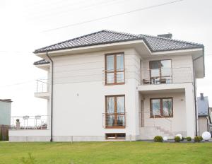 a white house with a black roof at Willa-Wita in Kalwaria Zebrzydowska