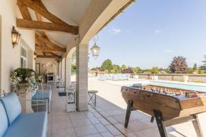 an outdoor patio with a pool table and a pool at Grande villa d'exception en Normandie tennis, piscine, jacuzzi, salle de fitness in Muids
