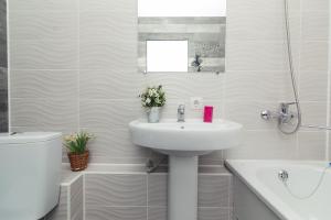 Un baño blanco con lavabo e inodoro. en Апартаменты возле ТЦ Лавина 1 этаж, en Sumy 23 fotos más