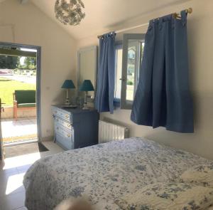 a bedroom with blue curtains and a bed and a window at Grande villa d'exception en Normandie tennis, piscine, jacuzzi, salle de fitness in Muids +40 photos