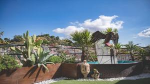um jardim com uma estátua de um pássaro e uma piscina em B&B Panoramic em Valguarnera Caropepe