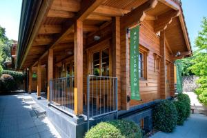 um edifício de madeira com um sinal verde em Hotel Somlom - ECO Friendly Montseny em Sant Esteve de Palautordera