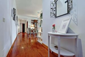 a hallway with white walls and a table with a picture at Colosseo Sunset Apartment in Rome