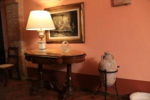 un tavolo con una lampada e un quadro sulla parete di Villa Giuncheto a Corsano