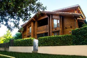 una casa de madera con una valla delante en Hotel Somlom - ECO Friendly Montseny, en Sant Esteve de Palautordera