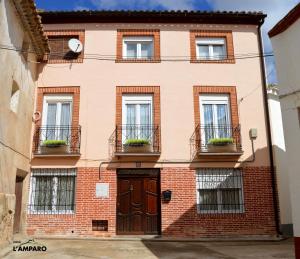 een bakstenen gebouw met ramen en een deur bij Casa rural L´Amparo -3 espigas- Categoría superior-15 personas in Navarrete del Río