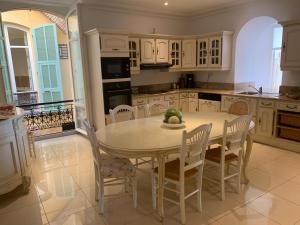 una cocina con mesa blanca y sillas. en Seagulls, en Villefranche-sur-Mer