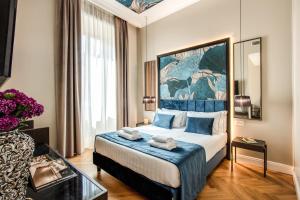 a hotel room with a large bed with blue pillows at Hotel 55 Fifty-Five - Maison d'Art Collection in Rome
