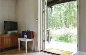 a living room with a television and a sliding glass door at Beautiful Home In Frederiksvrk With 2 Bedrooms in Liseleje