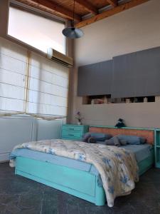 1 dormitorio con 1 cama azul en una habitación en Alternative country house 10 minutes from Athens airport en Artemida