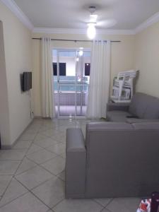 salon z kanapą i telewizorem w obiekcie Condomínio Pedra Coral w mieście Ubatuba
