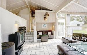 Vester SømarkenにあるAwesome Home In Nex With 4 Bedrooms, Sauna And Wifiのリビングルーム(テレビ付)、壁にシマウマの頭
