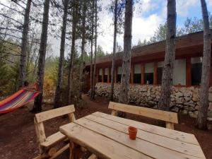 una mesa de madera y una hamaca frente a un edificio en Omaya Eco Village, en Gaytaninovo