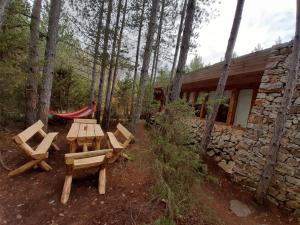 ein Picknicktisch und Stühle im Wald neben einer Hütte in der Unterkunft Omaya Eco Village in Gaytaninovo