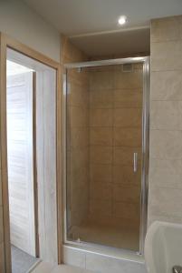 a shower with a glass door in a bathroom at Willa Alaska in Karpacz