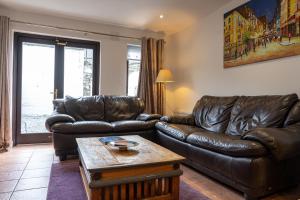 a living room with a leather couch and a coffee table at Liberty Townhouses in Dublin