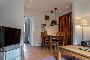 a living room with a tv and a table and chairs at Liberty Townhouses in Dublin
