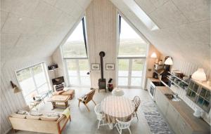 BolilmarkにあるBeautiful Home In Rm With 2 Bedrooms And Wifiの屋根裏のリビングルーム(テーブル、椅子付)