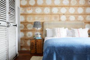 a bedroom with a blue bed and a wooden wall at Artist Residence Cornwall in Penzance