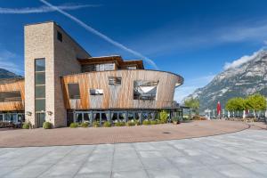 a building in front of a mountain at Apart Holidays - Marina Walensee in Unterterzen
