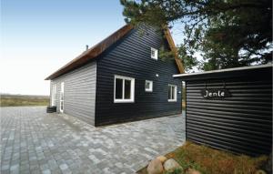 a black house with a garage next to it at Beautiful Home In Rm With 2 Bedrooms And Wifi in Bolilmark