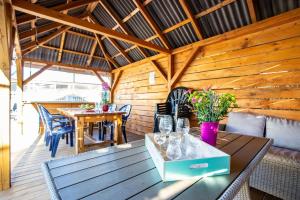 patio ze stołem i krzesłami oraz drewnianą ścianą w obiekcie Plaża Apartament w mieście Ustronie Morskie