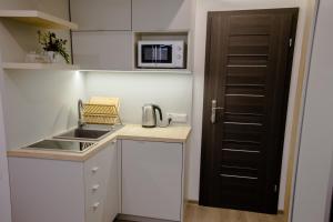a small kitchen with a sink and a microwave at ULMA studio in Wieliczka