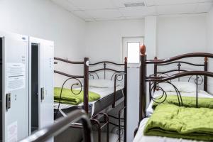 a room with two bunk beds with green sheets at The Hostel ЖД Вокзал Центр in Kyiv